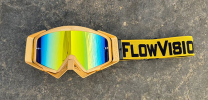 Goggles with a gold frame and reflective lenses on a textured surface, featuring 'FlowVision' branding.