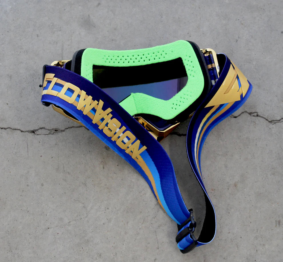 Goggles with blue and gold strap on a gray concrete surface