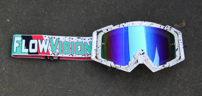 Motocross goggles with colorful reflective lenses and a 'Flow Vision' strap on a dark background