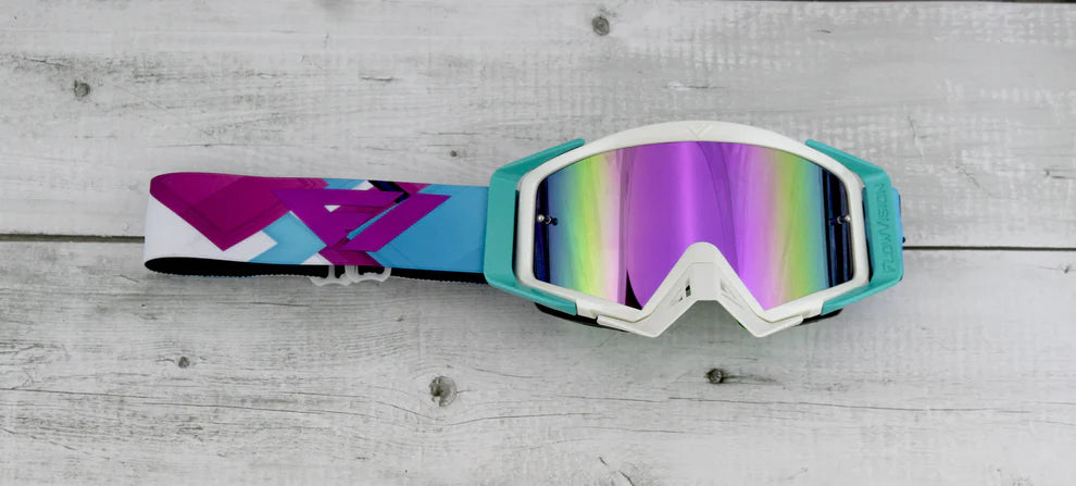 MX goggles with colorful lens on a wooden surface