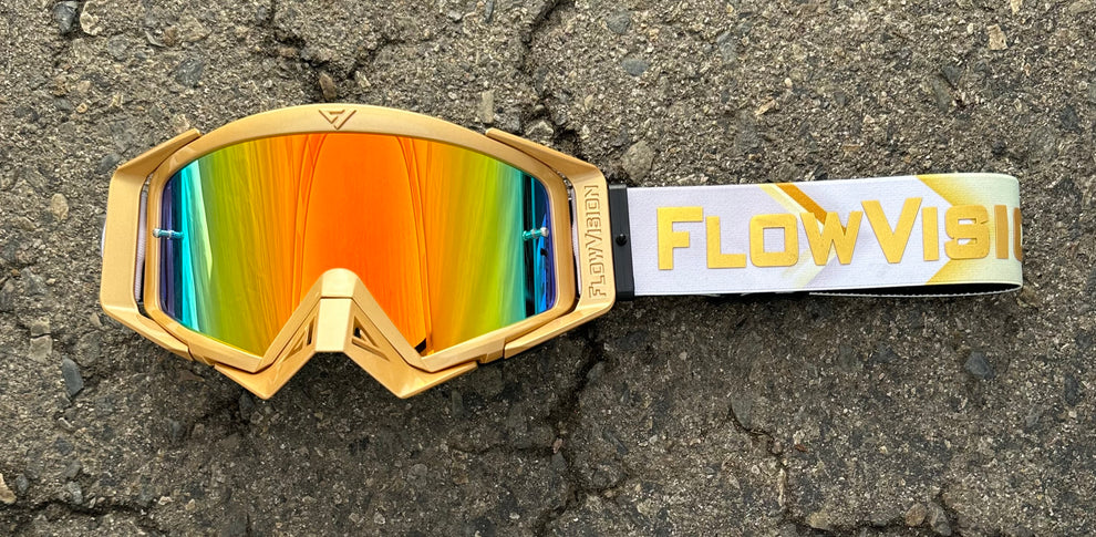 FlowVision Gold Leaf gold-framed goggles on a textured surface.