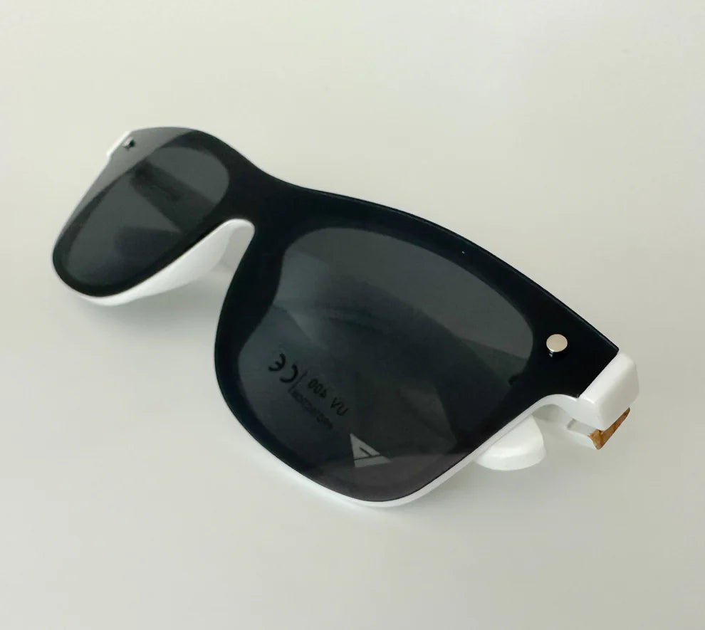 Black sunglasses with white frames on a light gray background