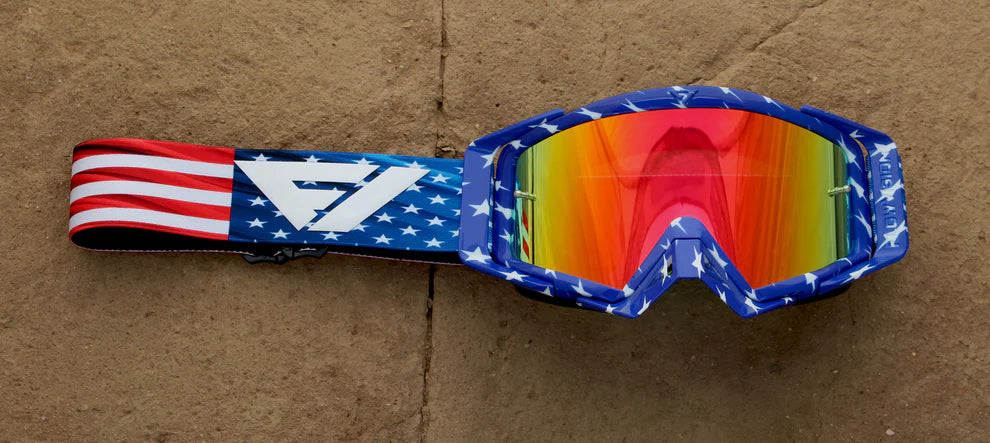 Goggles with American flag strap on a brown surface
