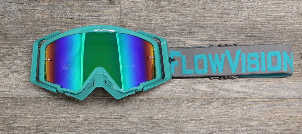 Teal goggles with reflective lenses on a wooden surface, featuring 'FlowVision' branding.