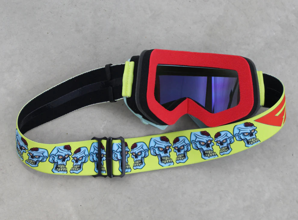Goggles with a colorful strap featuring cartoon skulls on a gray background