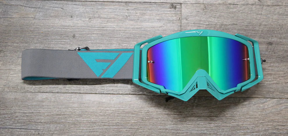 Teal goggles with a colorful lens on a wooden surface