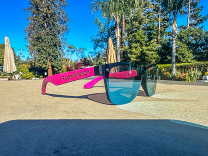 Sunglasses with pink arms and blue lenses on a surface outdoors