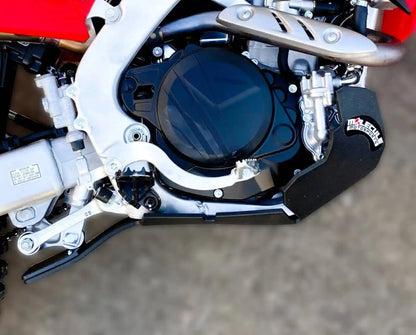 Close-up of a motorcycle engine with Molecule Motorsports skid plate and branding on a blurred background